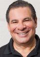 Phil Swift smiling in a casual black shirt, known for his energetic personality and innovative product demonstrations.