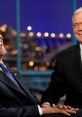 Late night talk show hosts share a lighthearted moment, showcasing humor and engaging conversation.