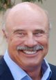 Dr. Phil smiling confidently in a blue shirt, showcasing his engaging personality and approachability in media appearances.