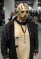 Jason Voorhees cosplay at a convention, featuring iconic hockey mask and tattered clothing, creating a chilling atmosphere.