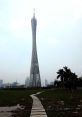 Guangzhou Tower rises majestically above lush greenery and a winding pathway, showcasing modern architectural design.