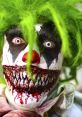 Scary clown with green hair and creepy makeup, featuring sharp teeth and blood, perfect for horror-themed events.