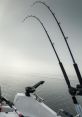 Trolling fishing rods set in a calm, foggy water landscape ready for a day of fishing adventure.