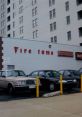 Signage of "Fire Tone" on a building with parked cars and yellow safety poles in an urban setting.