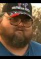 Man with glasses and a Southern-style cap, embodying the spirit of Georgia Brawler culture in a rural setting.