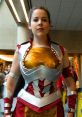 Female cosplayer in a golden and red Conlady costume with silver armor details at a comic convention.