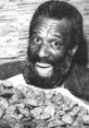 Cheerful man showcasing a large plate of cookies, embodying the playful spirit of the Creepy Cookie Guy.