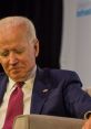 Sleepy Joe Biden appears contemplative, wearing a suit and pink tie during a public event, focused on pressing matters.