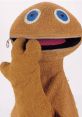 Zippy from Rainbow smiles playfully, showcasing his signature blue eyes and zippered mouth in a vibrant display of fun.