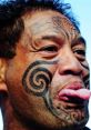 Man with traditional facial tattoos and playful expression showcasing Maori culture, embodying the Crazy Kiwi spirit.