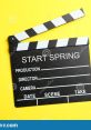 Black film clapboard with "START SPRING" on yellow background, perfect for film production and creative projects.