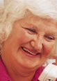 Smiling older woman with white hair, promoting positivity and support in drug and alcohol recovery efforts.