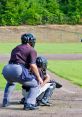 Umpire calls a strike as a baseball catcher prepares, showcasing the intensity of a sunny day at the diamond.