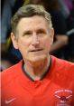 Sergeant Chubick smiles while coaching basketball, wearing an Omaha South jersey, showcasing his passion for the sport.