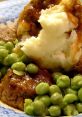 Delicious plate of meatloaf with gravy, creamy mashed potatoes, and vibrant green peas, perfect for a nostalgic meal.