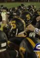 Team huddles for FNF game, showcasing determination and unity in football uniforms with prominent yellow and black helmets.