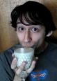 Young man playfully sipping from a decorative glass, highlighting a quirky moment related to Yandere Dev and EvaXephon.