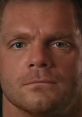 Close-up of Chris Benoit's intense expression, showcasing his piercing eyes and strong jawline, reflecting his wrestling persona.