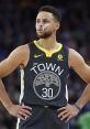 Stephen Curry in a black "The Town" jersey, focused on the game with determination during an NBA matchup.