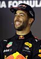 Daniel Ricciardo smiling during a press event, wearing Red Bull Racing team gear, showcasing his charismatic personality.