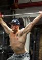 Man performing a snatch lift with a barbell in a gym, showcasing strength and focus in athletic training.