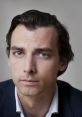 Close-up portrait of Thierry Baudet with a serious expression, showcasing his distinct features and hairstyle.