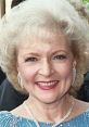 Betty White smiles brightly, showcasing her iconic style and charm at an event, embodying her timeless celebrity appeal.