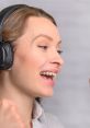 Woman with headphones passionately recording her voice, showcasing a vibrant and engaging expression in the studio.