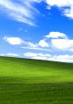 Vibrant green hillside under a bright blue sky with fluffy clouds, iconic background from Windows XP aesthetic.