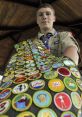 Scout proudly displays his achievements with a sash full of colorful merit badges at a scout camp.