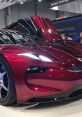 Sleek red sports car on display with dynamic lines, showcasing cutting-edge design and technology at an auto show.