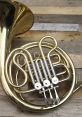 Elegant brass French horn with silver valves showcased on a rustic wooden surface, perfect for music lovers and musicians.