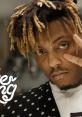 Juice Wrld poses with a peace sign, showcasing his signature style and unique personality in a trendy outfit.