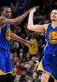 Kevin Durant and Klay Thompson celebrate a play during an NBA game, showcasing teamwork for the Golden State Warriors.