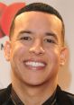 Smiling young man with short hair and earrings, showcasing charisma and confidence at a red carpet event.