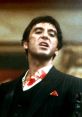 Tony Montana in a bloody suit, showcasing raw emotion in a key scene from Scarface, highlighting the film's intense drama.