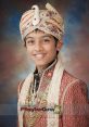 Young boy in traditional Indian bridal attire, adorned with jewelry and a decorative turban, radiating cultural elegance.