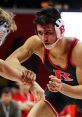 Wrestler in action during a match, showcasing intense focus and athleticism on the mat. Competitive wrestling tactics displayed.