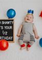 Happy 6 months baby celebration with a smiling infant, colorful balloons, and a festive sign marking the half birthday.