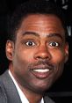 Smiling Chris Rock at a public event, showcasing his charismatic personality and vibrant energy as a renowned comedian.