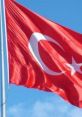 Turkish flag waving in the wind against a blue sky, symbolizing national pride and identity in Turkey.