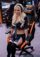 Cosplayer in a sailor outfit poses in a gaming chair, showcasing the playful allure of the sexy gamer girl meme culture.