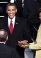 Barack Obama smiles while taking the oath of office, holding the Bible with Michelle Obama during the inauguration ceremony.