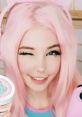 Happy gamer girl with pink hair and cat ear headphones, holding gaming accessories and winking playfully.