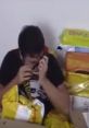 Young man surrounded by colorful packages, reacting to surprises from "Adam bok göndermiş (kısa sesler)." Excitement captured!