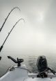 Two fishing rods bent over a calm, misty lake, with a motorboat's controls visible, ideal for a peaceful trolling adventure.