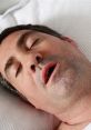 Man asleep with mouth open, illustrating the effects of loud snoring on sleep quality and nighttime disturbances.