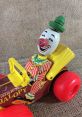 Vintage Fisher-Price clown toy car featuring a smiling clown with a red nose and colorful striped outfit. Perfect for collectors.