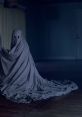 Eerie ghost figure draped in gray cloth, haunting an empty room with dim lighting, evoking chilling supernatural vibes.