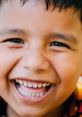 Joyful boy with a big smile, showcasing bright teeth and twinkling eyes, embodying the carefree spirit of childhood.